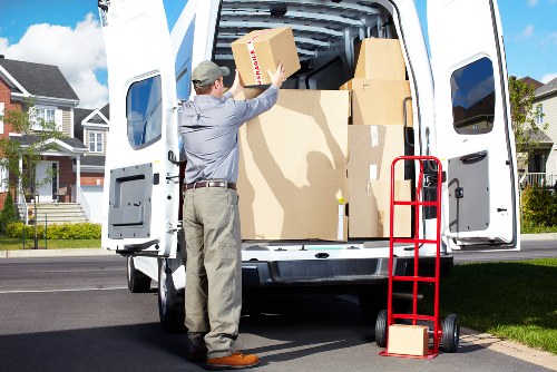 Movers carrying furniture through a West Kensington property entrance