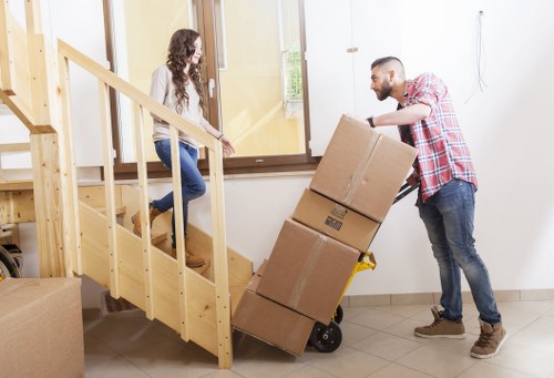 Local furniture collection team handling sofa and chair pick-up in a West Kensington flat