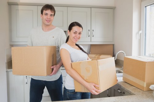 Removal staff handling commercial equipment during a move in West Kensington